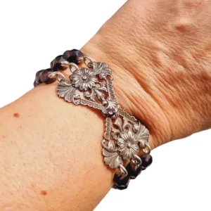 Antique silver modernist bracelet, floral motif and garnet glass beads.